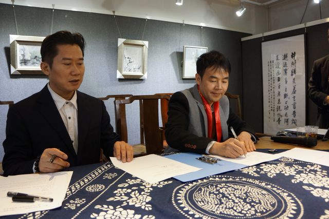 叶光荣(右)在设立叶光荣诗歌奖协议上郑重地签下自己的名字.JPG